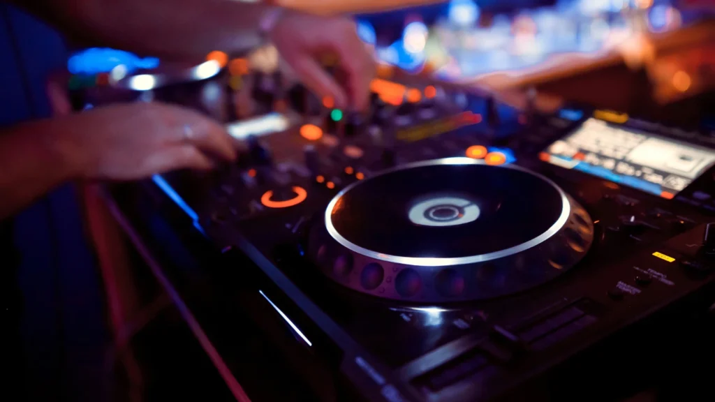 Close-up of DJ equipment with hands adjusting controls – DJ by the Hour package for flexible event entertainment in Thunder Bay